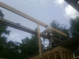 Carpenter setting a ridge beam over a new addition frame — Ice Dam Removal by Roofing Brothers in Ottumwa