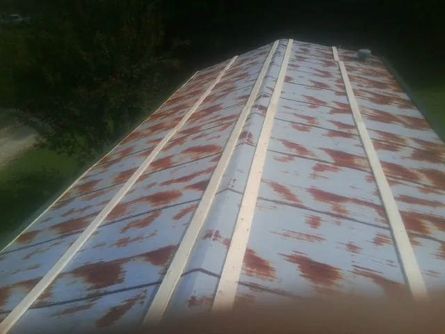 Rusted metal roof panels with new wood purlins before replacement — Storm Damage Roof Repair in Ottumwa by Roofing Brothers