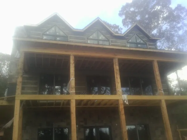 Dormers and porch framing on a large log home under construction — Roof Coating work by our crew in Ottumwa